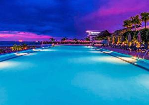 a large swimming pool at a resort at night at Holiday Inn Melaka, an IHG Hotel in Malacca