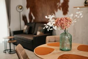 a vase with flowers on a table in a living room at Les Gîtes de l'Altévic in Hattstatt