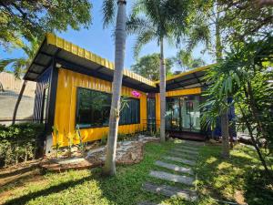 żółty dom z palmami przed nim w obiekcie Beach Box at Pran w mieście Sam Roi Yot