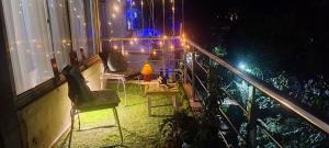 two chairs and lights on a balcony at night at Private & Cosy 2 BHK with Homely Kitchen, Balcony-Garden View -Solo,Couple & Group Friendly Central Delhi,Hauz Khas,AIIMS,INA in New Delhi