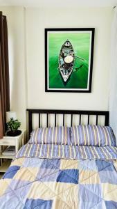 a bedroom with a bed with a picture on the wall at MM’s Place at Woodhills Tagaytay in Tagaytay