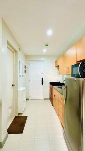 a kitchen with a stainless steel refrigerator and wooden cabinets at MM’s Place at Woodhills Tagaytay in Tagaytay