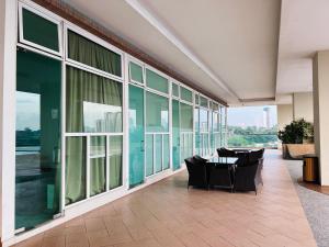 ein Zimmer mit Stühlen und Tischen in einem Gebäude mit Fenstern in der Unterkunft Paragon Residence 2BR nr CIQ/KSL/Midvalley/JBCC by Our Stay in Johor Bahru