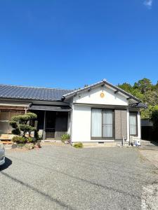 Uma casa branca com uma entrada à frente. em Boss'sHouse犬ok天然温泉あり em Kirishima