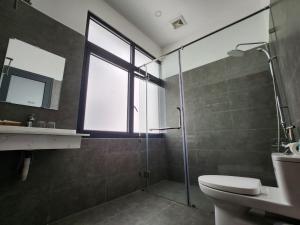 baño con ducha y aseo y ventana en Lana Inn - Grand World Phú Quốc en Phu Quoc