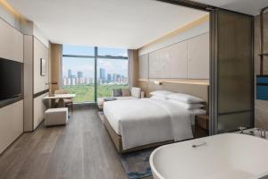 a hotel room with two beds and a tub at Shaoxing Marriott Hotel Shangyu in Shaoxing