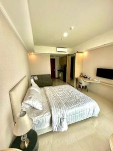 um quarto com uma cama, uma secretária e uma televisão em GREEN SEDAYU APARTMENT b28 em Jakarta