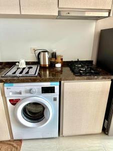 une cuisine avec une cuisinière et une machine à laver dans l'établissement GREEN SEDAYU APARTMENT b28, à Jakarta