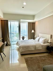 um quarto com uma cama grande e uma janela grande em GREEN SEDAYU APARTMENT b28 em Jakarta