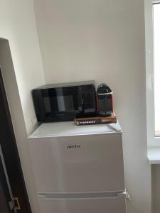 a microwave sitting on top of a refrigerator at Studio Central Doamnei in Bucharest
