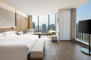 a hotel room with a large bed and a large window at Shaoxing Marriott Hotel Shangyu in Shaoxing