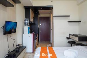 Habitación con cama, TV y nevera. en AzzaRoom panoramic, en Bandung