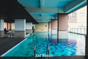 een zwembad met blauw water in een gebouw bij AzzaRoom panoramic in Bandung