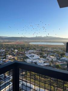 un troupeau d’oiseaux volant dans le ciel au-dessus d’une ville dans l'établissement Cozy condo lake view 15th floor, à León