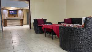 a room with a table and chairs and a kitchen at Hotel les Polygones Kribi in Kribi