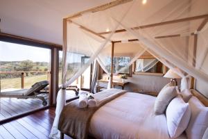 um quarto com uma cama de dossel e uma varanda em Turon Gates - Mountain Retreat em Capertee