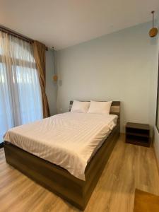 um quarto com uma cama grande e lençóis brancos em Lana Inn - Grand World Phú Quốc em Phu Quoc