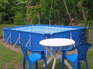 una mesa y sillas frente a una piscina azul en CASA CAMPESTRE EL RINCON VERDE, en Rivera