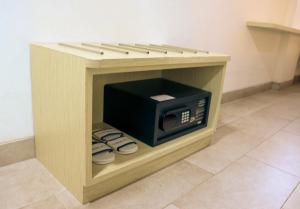 un forno a microonde in una scatola di legno con TV di Cordela Inn R Sukamto Palembang a Palembang