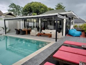 un patio al aire libre con piscina y una casa en Beautiful private 3 bedroom villa with pool and gym, en Rawai Beach