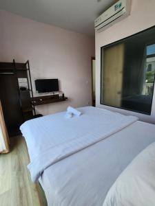 a bedroom with a white bed with a large window at Lana Inn - Grand World Phú Quốc in Phu Quoc