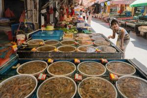 uma mulher em frente a um mercado com muita comida em W Xiamen-Next to shopping center&Exhibition Center em Xiamen
