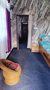a room with a bed and a couch in a cave at Tea corner Guest house in Darjeeling