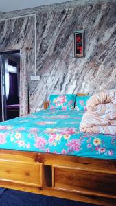 a bedroom with a wooden bed with a blue comforter at Tea corner Guest house in Darjeeling