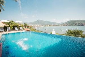 Una gran piscina con vista al agua. en Villa del Pescador, en Zihuatanejo