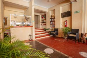 - un hall avec un escalier, des chaises et des livres dans l'établissement Villa del Pescador, à Zihuatanejo