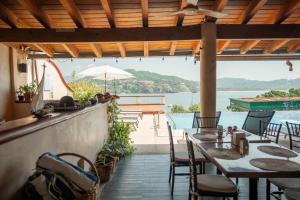 un restaurante con mesas y sillas y vistas al agua en Villa del Pescador en Zihuatanejo