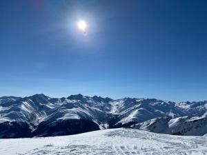 una montaña cubierta de nieve con el sol en el cielo en Ideal für gemütliche Ski-, Wander-, und Bergferien, en Disentis