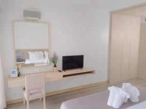 a bedroom with a bed and a television on a desk at D Varee Mai Khao Beach Resort, Thailand in Mai Khao Beach