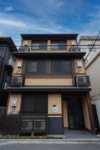 un grand bâtiment avec une clôture noire devant lui dans l'établissement unito residence KYOTO Gojo, à Kyoto
