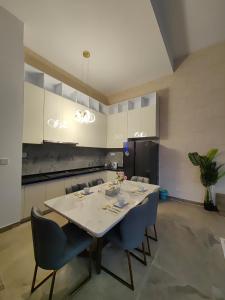 a kitchen with a table with chairs and a refrigerator at Xtu Golf Villa Forest City三房独栋别墅 in Kampong Tiram Duku Kiri