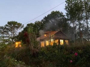 a house on a hill with smoke coming out of it at Romantic house on a pine hill Dalat in Xuan An