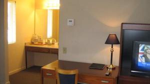 Cette chambre d'hôtel dispose d'une télévision et d'un bureau avec une lampe. dans l'établissement Westhaven Inn, à Pollock Pines