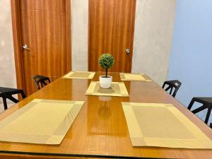 a large wooden table with a potted plant on it at Spacious 2 Bedroom perfect for Family & Friends, Good for 4pax allows to stay 10pax in Manila