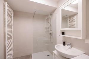 ein weißes Bad mit einem Waschbecken und einer Dusche in der Unterkunft NEW! Convenient ViennaLove Apartment WienMeidling in Wien