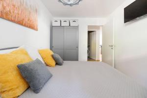 ein Schlafzimmer mit einem großen weißen Bett mit gelben Kissen in der Unterkunft NEW! Convenient ViennaLove Apartment WienMeidling in Wien