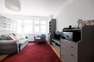 ein Wohnzimmer mit einem Sofa und einem TV in der Unterkunft NEW! Convenient ViennaLove Apartment WienMeidling in Wien