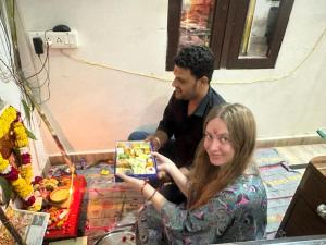 un hombre y una mujer sosteniendo una caja de comida en Hotel Zoola Palace en Pushkar