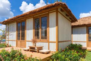 a house with a deck with a bench and windows at K-Town Resort Phan Thiet in Phan Thiet