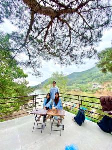 a man and two women sitting at a picnic table at Lều biệt thự in Hanoi