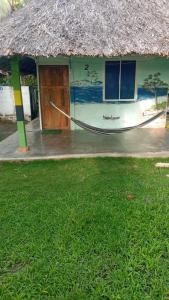 a house with a hammock in front of it at Cabañas el paisa tours in Arboletes