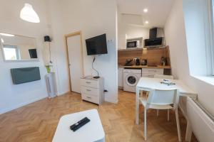 niewielki apartament ze stołem i kuchnią z kuchenką mikrofalową w obiekcie L'Orchidée - ZMN Conciergerie w mieście Saint-Quentin