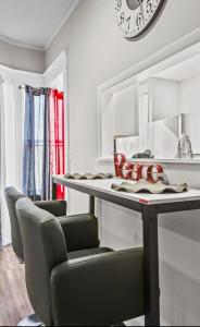 a kitchen with a table with chairs and a clock at St Paul Fry Street Den Suite#1 in Saint Paul