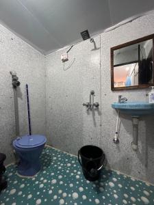 a bathroom with a blue toilet and a sink at Lacto Cressida Huts in Palolem