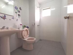 een witte badkamer met een toilet en een wastafel bij Green Hill Tanah Rata Cameron Highland in Tanah Rata +49 foto's