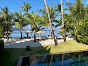 widok na ośrodek z palmami i basenem w obiekcie Laguna Beach House w mieście Ko Chang